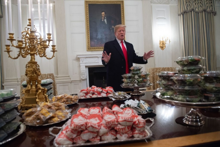 Donald presenting a table full with junk food to his guests at the white house during his first mandate