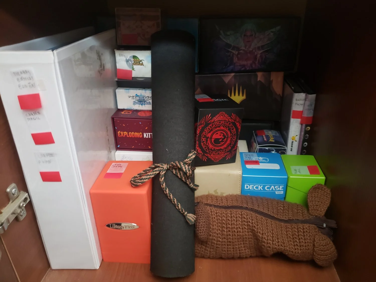 Foto interior de un mueble con cosas de juegos de mesa y cartas bien ordenadas.