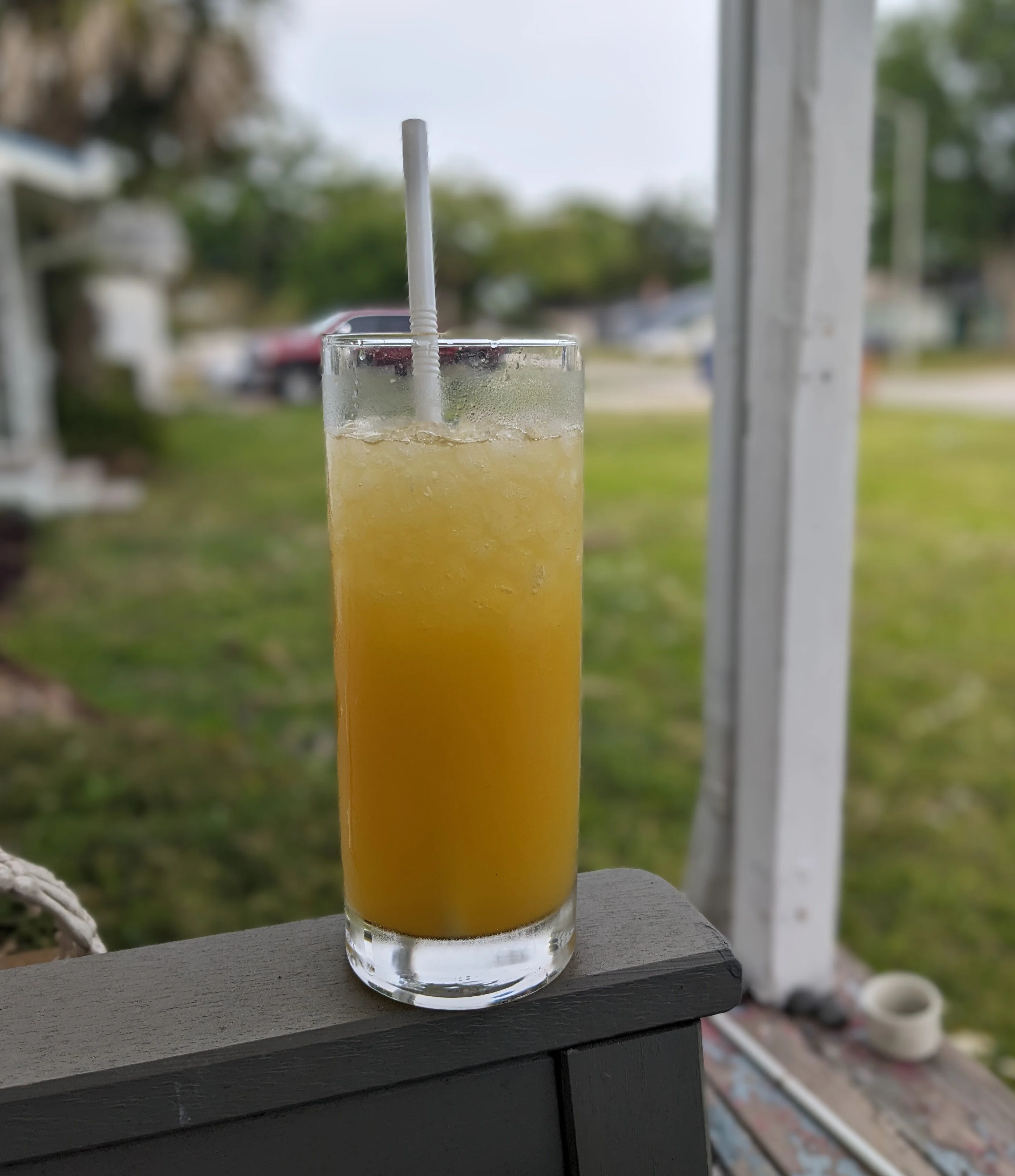 Image of orange drink in highball glass with white straw