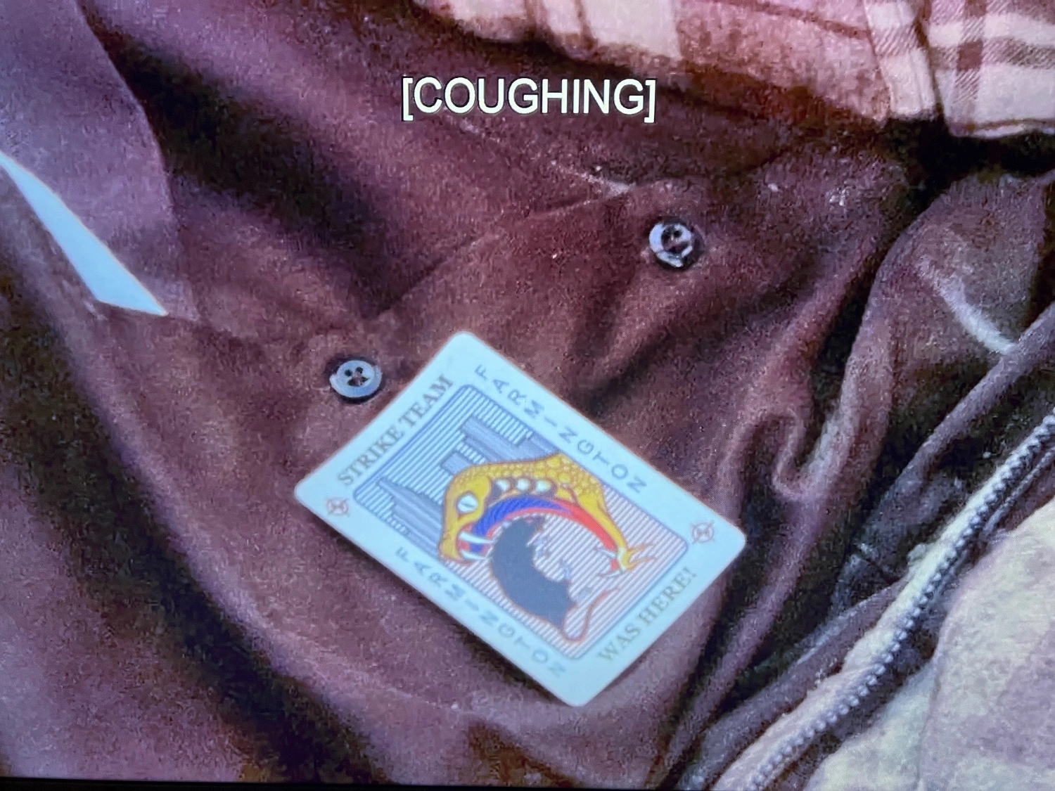 Screenshot of episode of TV show The Shield. There is a card laying on someone’s jacket that looks like a Balatro inspired joker